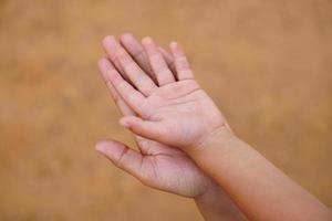 madre e hijo tomados de la mano para recibir algo foto