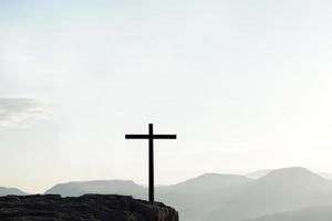 Cross silhouette on mountain nature background photo