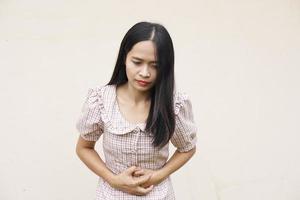 mujer sufre de dolor de estómago, gastritis crónica, concepto de hinchazón del abdomen foto