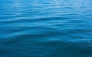 Blue water background with ripples Sea low angle view, Ocean, Wave.   Travel destination and nature environment concept. photo