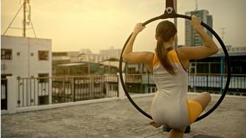 Woman in sportswear doing sky yoga on the rooftop in the evening when the sun set. Self care and health concepts. photo