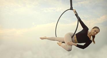 Woman in sportswear doing sky yoga on the rooftop in the evening when the sun set. Self care and health concepts. photo