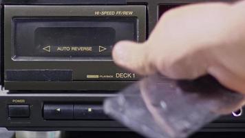 mannenhand voegt en speelt cassette af op oude cassettespeler video