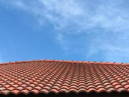 Perspective red roof tiles with copy space blue sky.