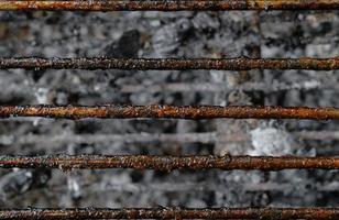 Top view close up dirty stains texture of charcoal grill after use with ashes background. photo