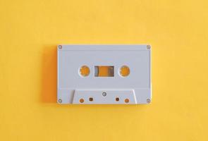 Top view photography of old plastic tape cassette on isolated yellow background. photo