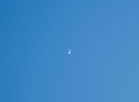 Crescent moon and clear day blue sky background. Minimal nature concept. photo