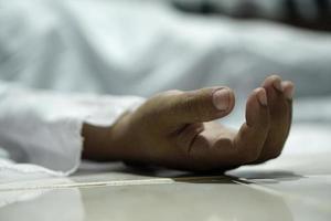 dead body laying on a floor.Focus at the hand photo