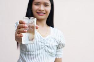 mujer asiática sosteniendo un vaso de agua fría para beber foto