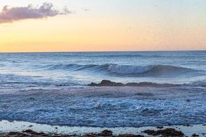 puesta de sol escénica sobre el mar. el sol se pone en el agua. el cielo nublado está pintado con colores brillantes. playa al atardecer en una noche de verano. Brasil. foto