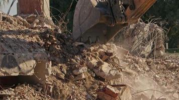 martillo hidráulico y máquina trasera de la excavadora cortadora de columnas trabajando en la demolición de antiguas casas de apartamentos video