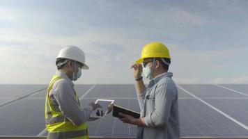 der ingenieur und der arbeiter, die im solarpanel-kraftwerk erneuerbare energien zusammenarbeiten.