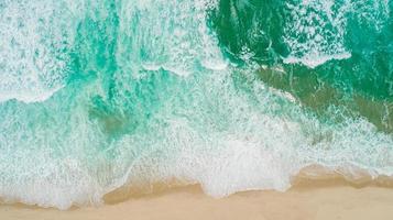Aerial shot of waves breaking on the shore. Colourful beach summer. photo