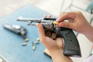 people load bullets into revolver gun photo