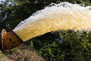 Splashing water gushing from a pipe. photo