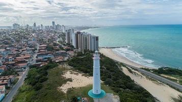 vista de ángulo bajo del faro en la parte superior de la frondosa duna en natal, brasil foto