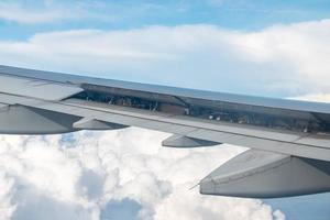 gran curva de ala de avión comercial... la vista del horizonte azul sobre las nubes desde la ventana del avión.
