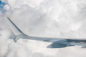 Curvatura de ala de avión comercial grande. la vista del horizonte azul sobre las nubes desde la ventana del avión.