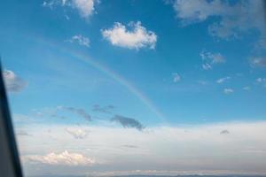 hermoso arco iris visto desde el interior de un avión en el aire foto