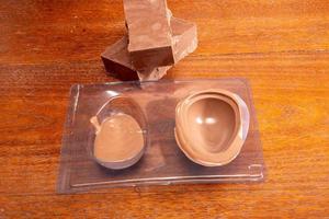 Homemade Easter egg factory. Making eggshell from easter egg with melted chocolate and a shape. photo