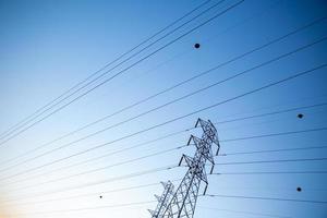 Look up High voltage of power transmission towers. Blue sky. photo