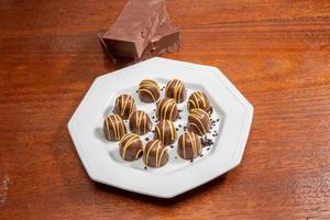 Homemade chocolate truffles. Delicious sweet temptation. Covered with yellow cream. photo