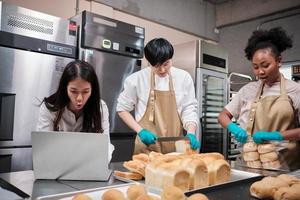 tres jóvenes amigos y socios de puesta en marcha de masa de pan y pasteles ocupados con trabajos de horneado caseros mientras cocinan pedidos en línea, empaquetan y entregan en una panadería, empresario de pequeñas empresas foto