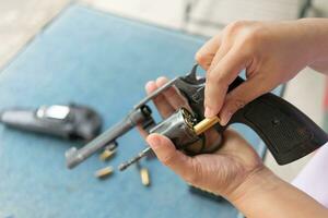 people load bullets into revolver gun photo