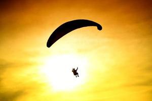 Silhouette of parachute on sunset photo