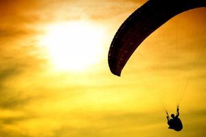 Silhouette of parachute on sunset photo