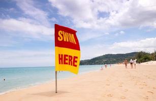 swimming here sign on the beach photo