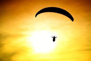 Silhouette of parachute on sunset photo