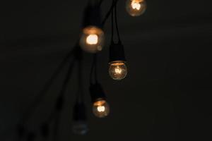 Retro light bulb hanging with dark space background for your decoration, concept of creativity photo