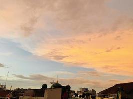 cielo crepuscular muy hermoso, una mezcla de colores naranja y azul. hermosa vista del cielo de la tarde. nubes, cielo y arcoíris que adornan el ambiente de la tarde. vista nocturna en Yakarta. difuminar foto