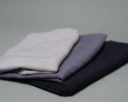 Stacks of nude colored veils neatly arranged on a gray background. Thin fabric blend of gray color that is ready to be used for Muslim women. Can also be used for sales displays. focus blur. hijab. photo