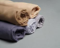 A roll of nude colored veil is neatly arranged on a gray background. Rolls of thin gray fabric that are ready to be used for Muslim women. Can also be used for sales displays. focus blur. hijab women.