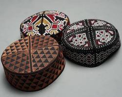 Collection of kopiah hat or peci with a variety of color and shape motifs. Peci that is usually used for Muslim men while praying to the mosque. Islamic cap isolated on white background. Ied mubarok. photo