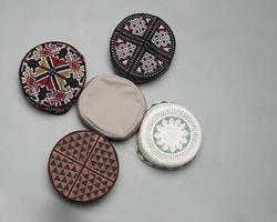 Collection of kopiah hat or peci with a variety of color and shape motifs. Peci that is usually used for Muslim men while praying to the mosque. Islamic cap isolated on white background. Ied mubarok. photo