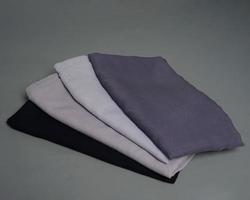 Stacks of nude colored veils neatly arranged on a gray background. Thin fabric blend of gray color that is ready to be used for Muslim women. Can also be used for sales displays. focus blur. hijab. photo