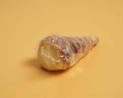 Indonesian cake shaped like ice cream with a cone sprinkled with sugar. This cake is usually called cumcum, or sometimes also called trumpet cake. The cake inside contains vanilla cream. focus blur. photo