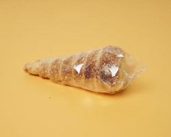 Indonesian cake shaped like ice cream with a cone sprinkled with sugar. This cake is usually called cumcum, or sometimes also called trumpet cake. The cake inside contains vanilla cream. focus blur. photo