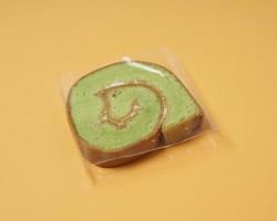 Slices of bread covered with cream butter are then rolled and sliced. Bread in the shape of a roll. The green color usually indicates the pandan flavor in the bread. Indonesian cake taste. focus blur. photo