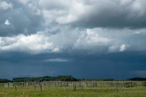 Wood Corral with approaching storm clouds, Saskatchewan, Canada. photo