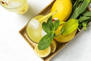 Fresh Lemonade or mojito cocktail with lemon, mint and ice photo