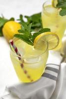 cóctel de limonada fresca o mojito con limón, menta y hielo foto