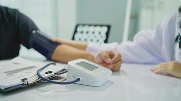 médico verificando a pressão arterial de paciente do sexo feminino. cuidados de saúde. monitoramento da pressão arterial de pacientes usando monitor de pressão arterial de braço no