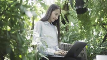 mujer trabajando en una laptop y relajándose en el jardín video