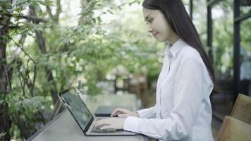 Frau, die am Laptop arbeitet und sich im Garten entspannt video