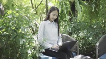 donna che lavora al computer portatile e si rilassa in giardino video