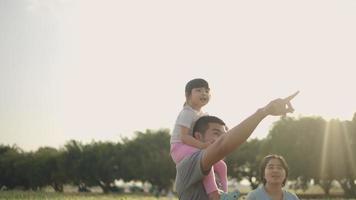 Ein asiatischer Vater nahm seine Tochter glücklich mit zum Sonnenblumenfeld. während des Sonnenuntergangs